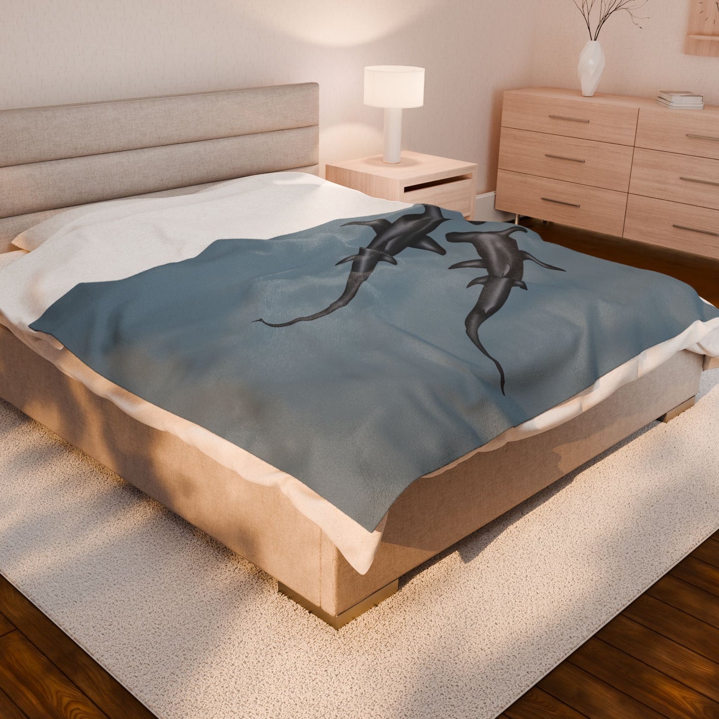 A large blue-grey velveteen plush blanket featuring two hammerhead sharks gliding through the fabric like it's their personal ocean—perfect for wrapping yourself in comfort with a side of bite. Shown on a queen size bed.