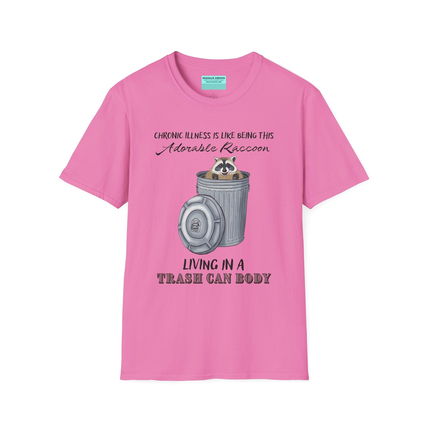 Pink t-shirt featuring an illustration of a raccoon in a metal trash can, with the phrase 'Chronic illness is like being this adorable raccoon living in a trash can body' printed on it.