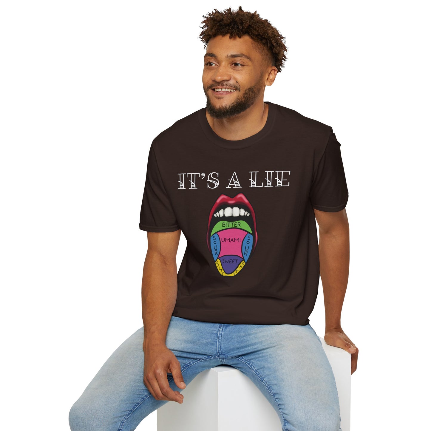 Man wearing a brown short-sleeve unisex t-shirt featuring a classic tongue taste map with the words “It’s a lie” boldly above it—busting the myth that different parts of your tongue taste different things. Sweet, salty, sour, bitter? Taste buds don’t discriminate!
