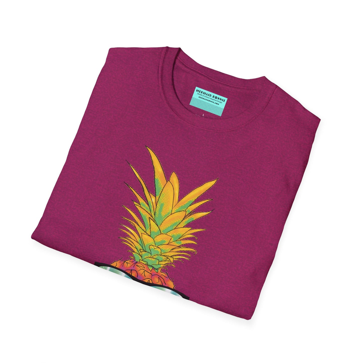 Folded fuscia t-shirt featuring a drawing of a pineapple wearing sunglasses.