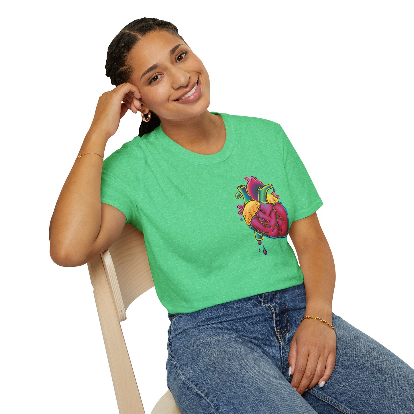 Woman wearing a green unisex short sleeve t-shirt featuring a bold neon anatomical heart front and off-center, complete with dripping blood vessels—because nothing says “wear your heart on your sleeve” like wearing it smack on your chest in highlighter tones.