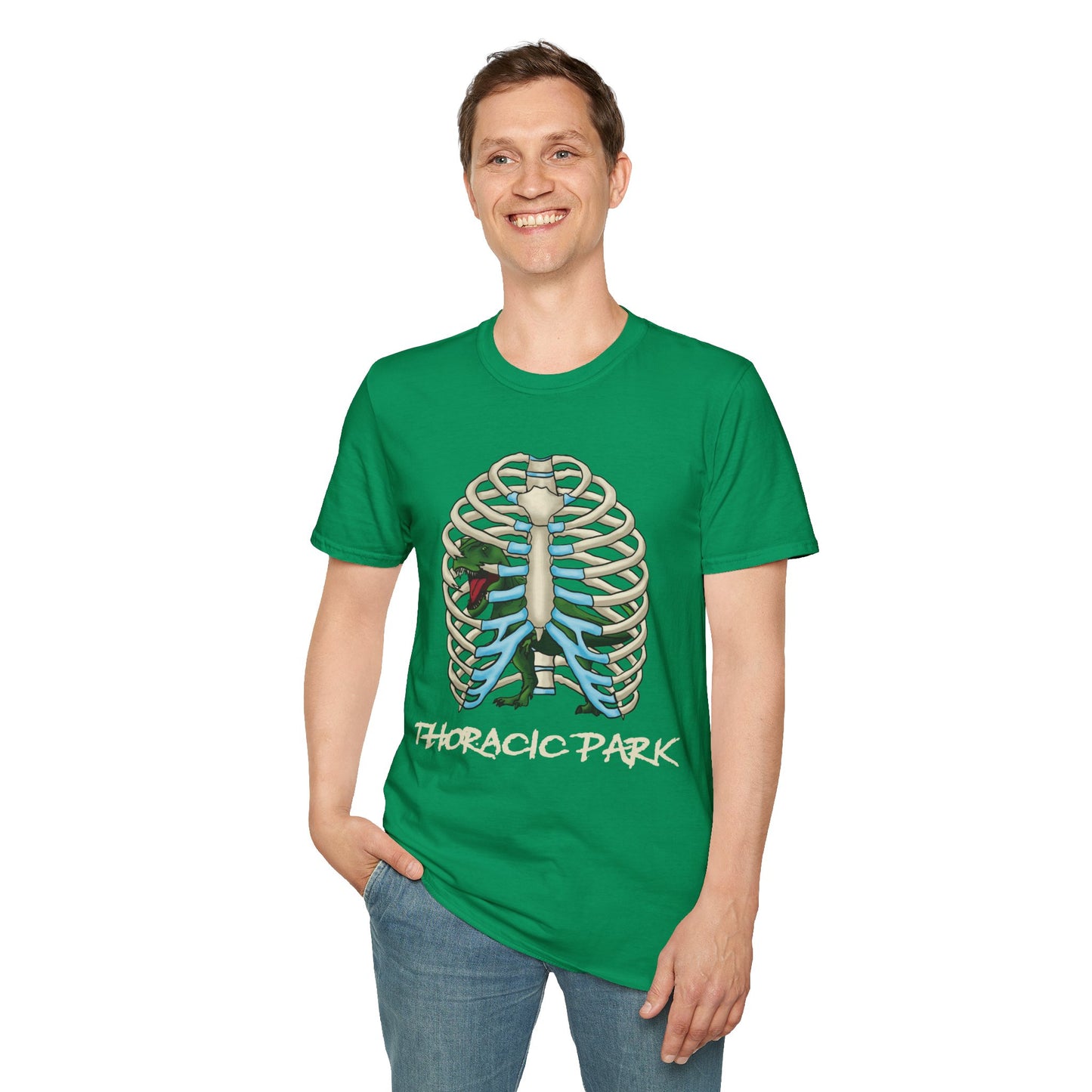 Man wearing a green unisex short sleeve tee with a clever Jurassic twist—an anatomical rib cage doubles as a prehistoric prison for a tiny T-Rex, with the punny caption "Thoracic Park" below. It's dino-mite meets anatomy class in the best way possible.
