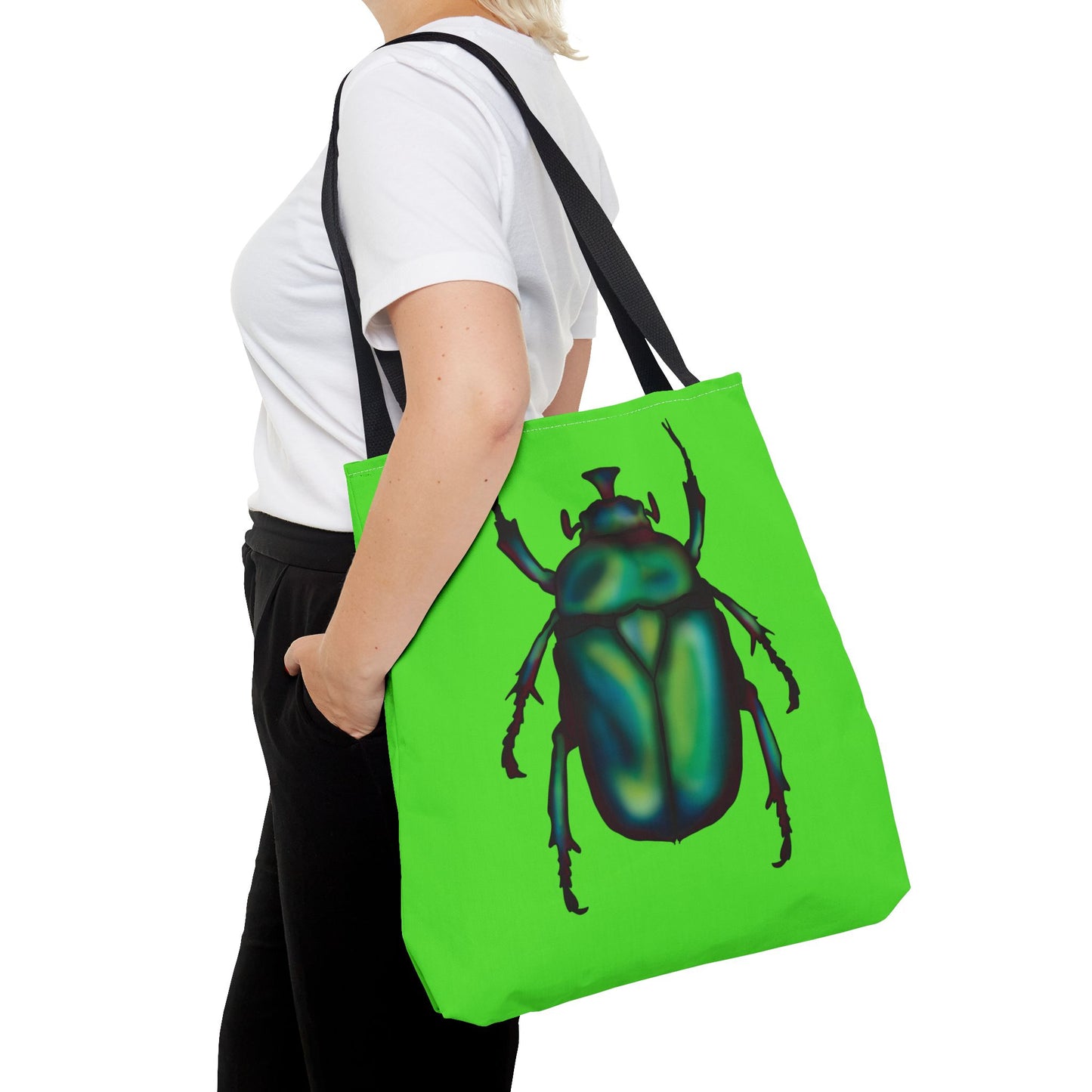 Large lime green tote bag with a black handle on a woman’s shoulder with her hands in pockets featuring an illustration of a June bug (green chafer beetle).