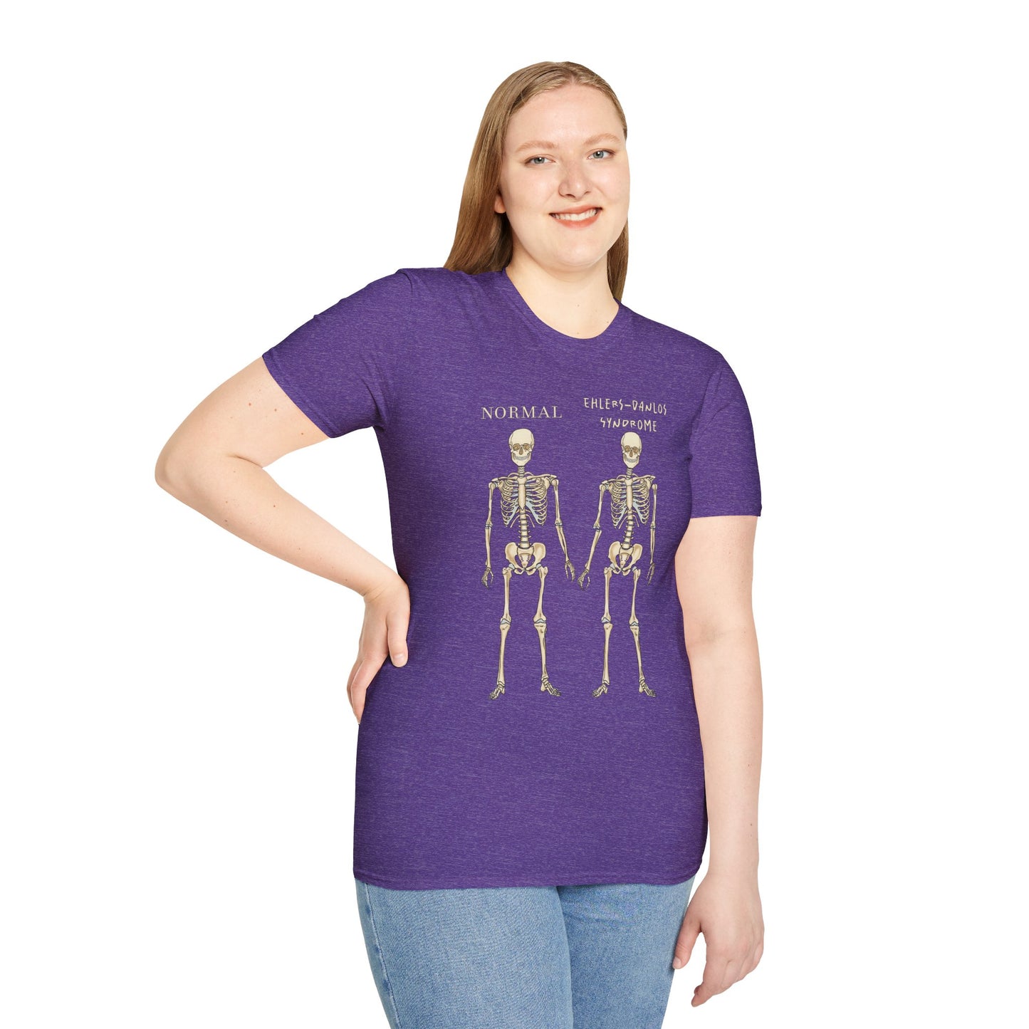 Woman wearing a purple unisex short sleeve t-shirt featuring two skeletons side by side—one labeled "normal," the other "Ehlers-Danlos Syndrome"—because connective tissue disorders deserve more visibility (and maybe a sense of humor, too).