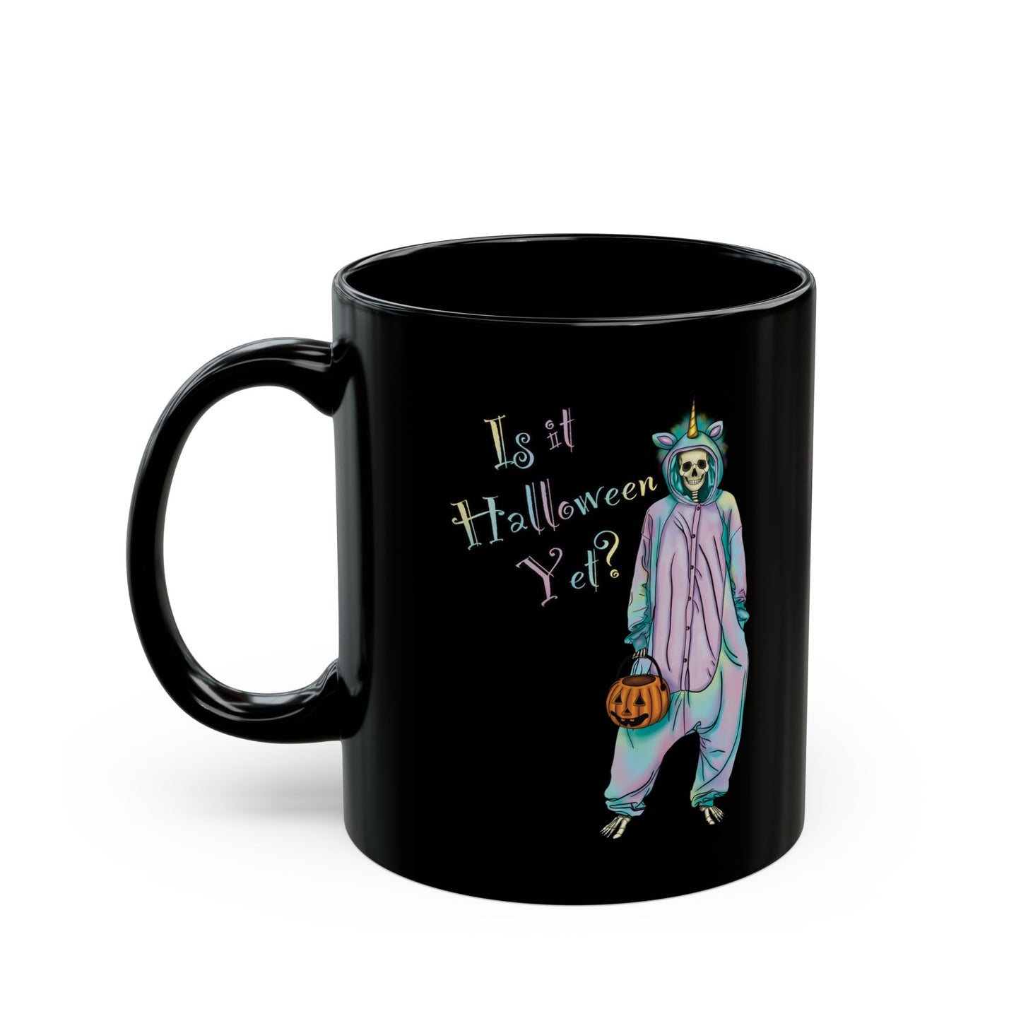 Left view of a small black coffee mug featuring a whimsical illustration of a skeleton dressed in a pastel unicorn onesie, complete with a horn and rainbow accents; the playful text reads "Is it Halloween yet?"—because spooky season should be year-round.