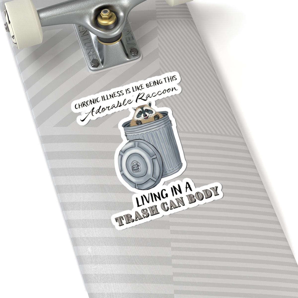Large sticker on a skateboard with a drawing of a raccoon sitting in a metal trash can, accompanied by the text: 'chronic illness is like being this adorable raccoon living in a trash can body.'