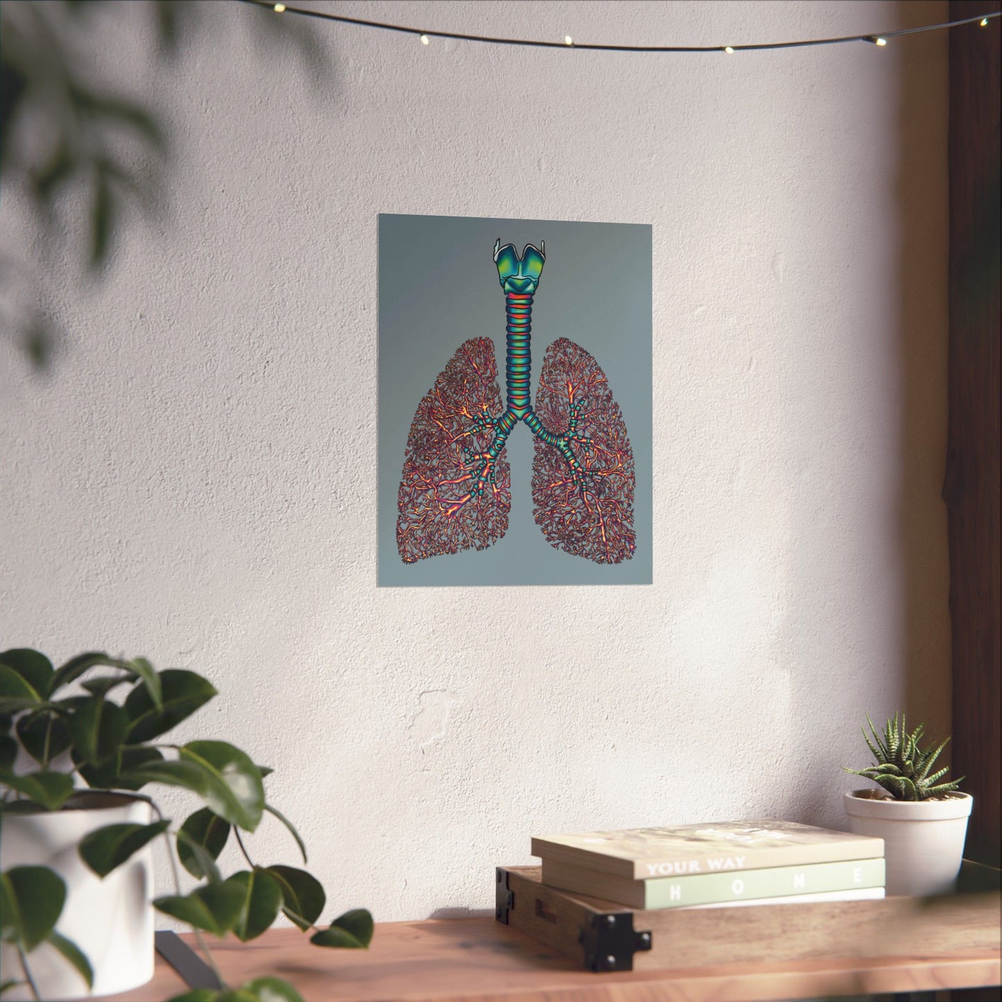Medium poster displayed on a wall in a home setting, featuring an illustration of anatomical lungs with detailed bronchial tree, trachea, and larynx, set against a blue-grey background.
