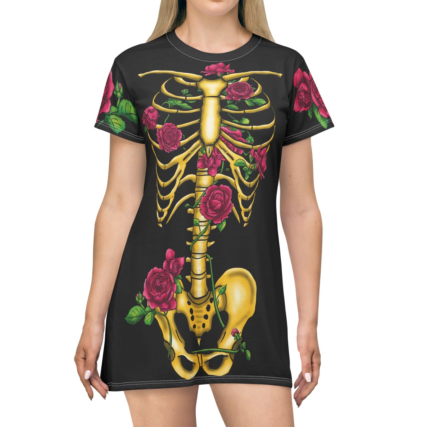 Anterior view of a woman wearing a black t-shirt dress featuring a gold anatomical illustration of the human skeleton on the back, adorned with blooming pink roses interwoven through the bones.