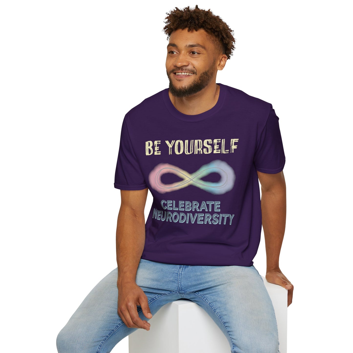 Man wearing a dark purple t-shirt featuring a pastel-colored rainbow infinity symbol, with the text 'Be yourself, celebrate neurodiversity'.