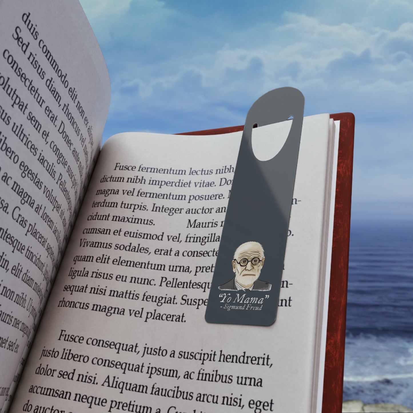Dark grey-blue aluminum bookmark featuring a portrait of Sigmund Freud with humorous text that reads 'Yo Mama – Sigmund Freud. The bookmark is shown in use holding a page