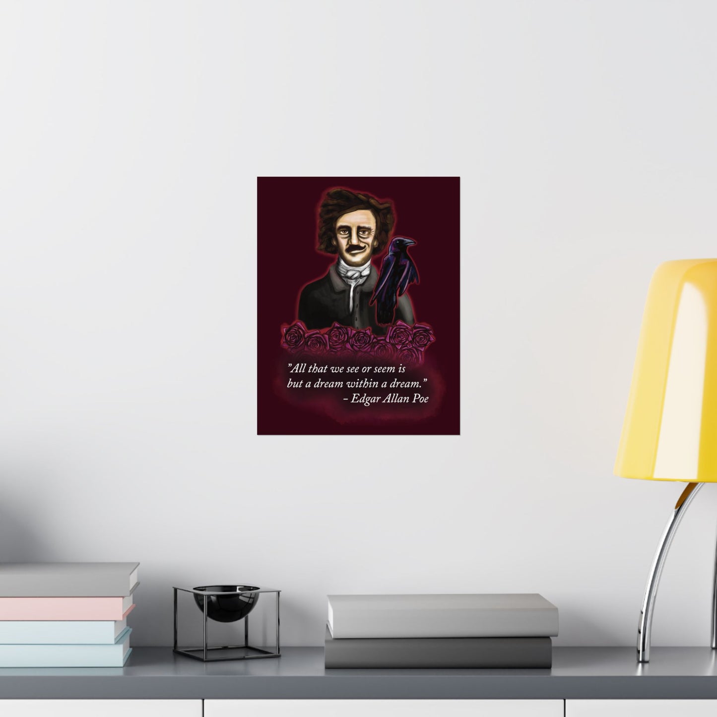 A small moody poster of Edgar Allan Poe hung in an office setting. He is wearing a wry smile as he’s surrounded by crimson roses and a raven, with a rich burgundy background—because even the master of macabre has a soft spot for gothic romance.