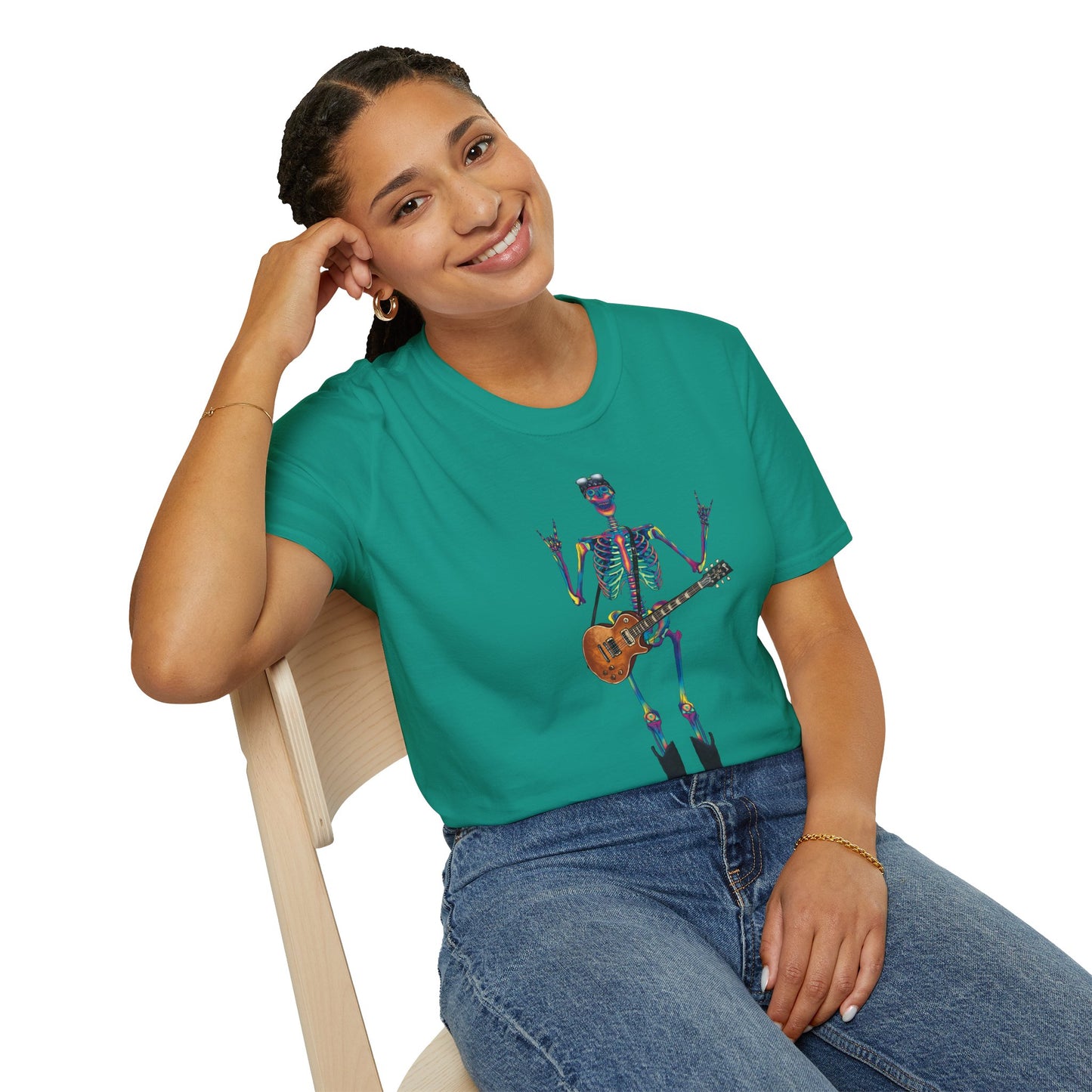 Woman wearing a blue green t-shirt featuring a tie-dye skeleton holding a guitar, dressed like a classic rocker with boots, a bandana, and rock-style clothing.
