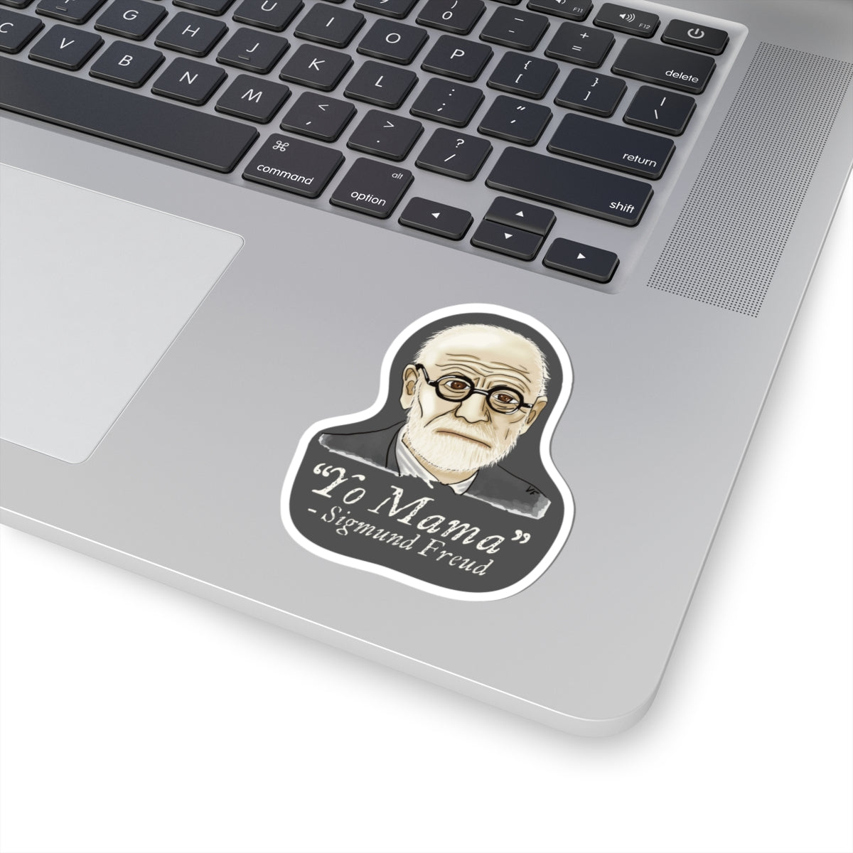 Small sticker adhered to a computer featuring a portrait of Sigmund Freud with the humorous quote 'yo mama' written below him.