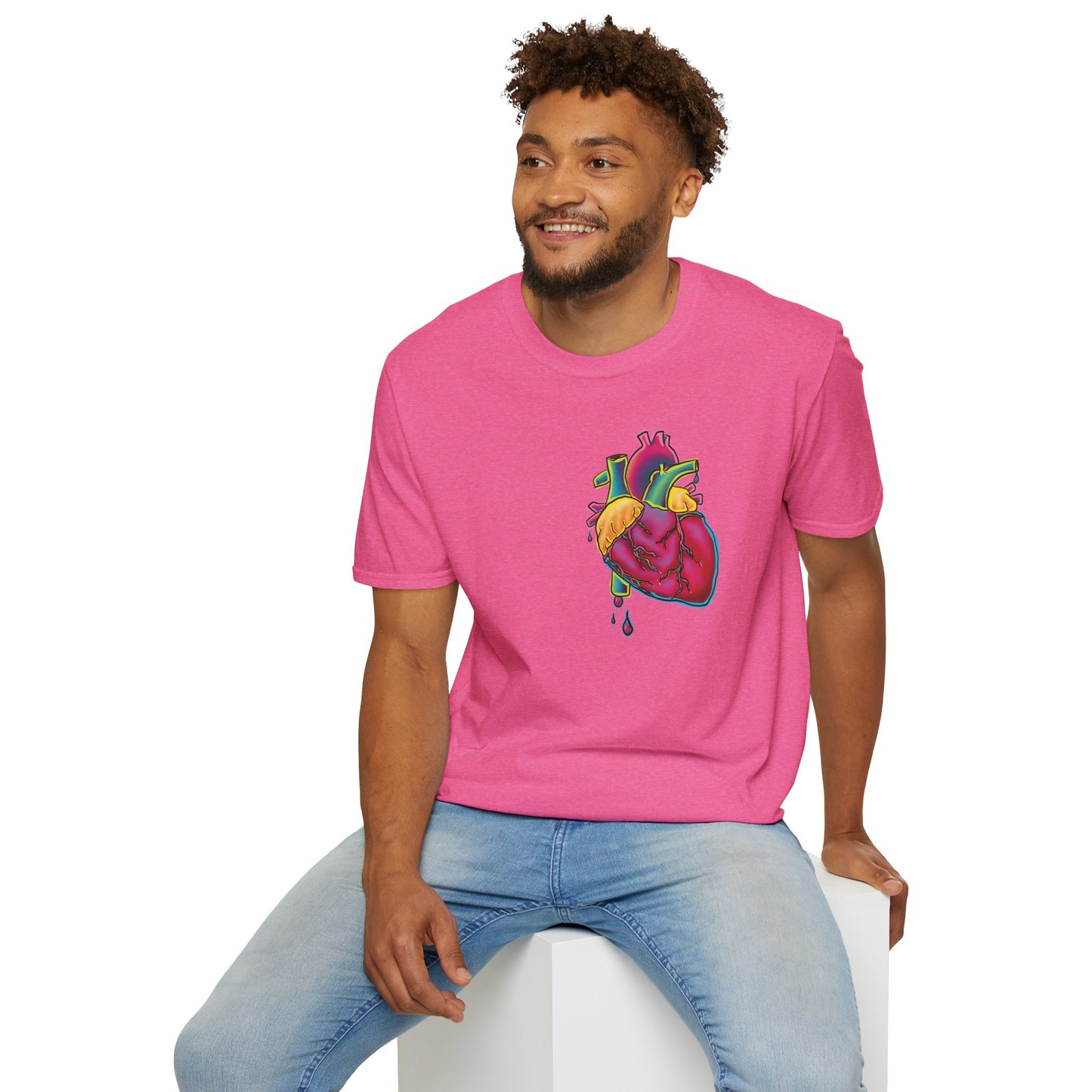 Man wearing a pink unisex short sleeve t-shirt featuring a bold neon anatomical heart front and off-center, complete with dripping blood vessels—because nothing says “wear your heart on your sleeve” like wearing it smack on your chest in highlighter tones.