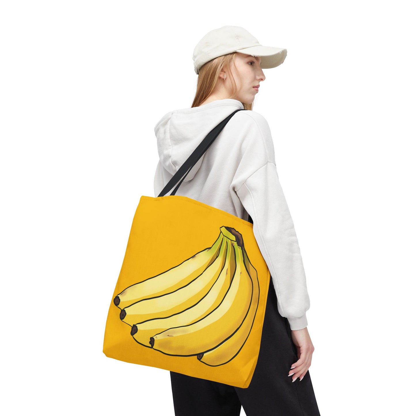 Woman carrying extra large yellow tote bag featuring a playful illustration of a bunch of bananas on the front, set against a solid yellow background.