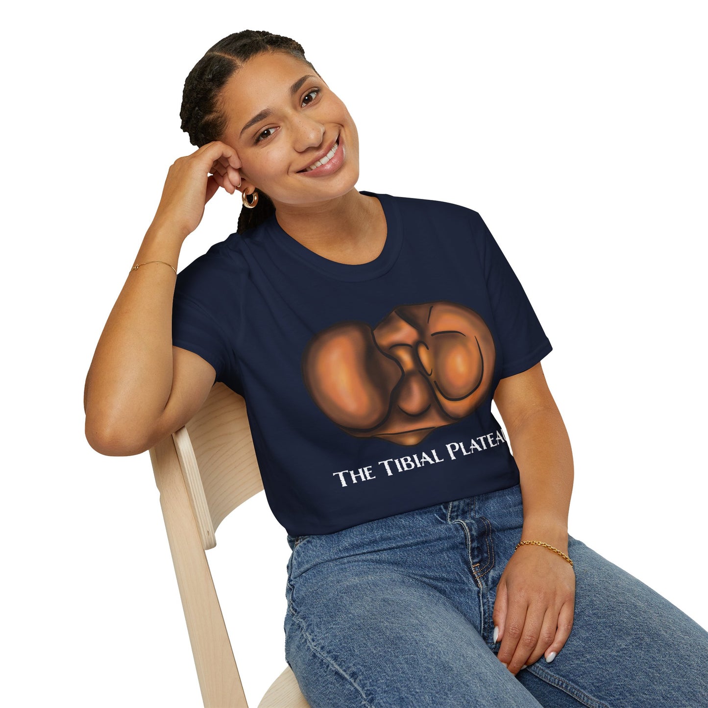Woman wearing a navy unisex short sleeve tee featuring a clever anatomical illustration of the tibial plateau, reimagined as a landscape with rolling hills—because who knew the tibia could be so scenic?