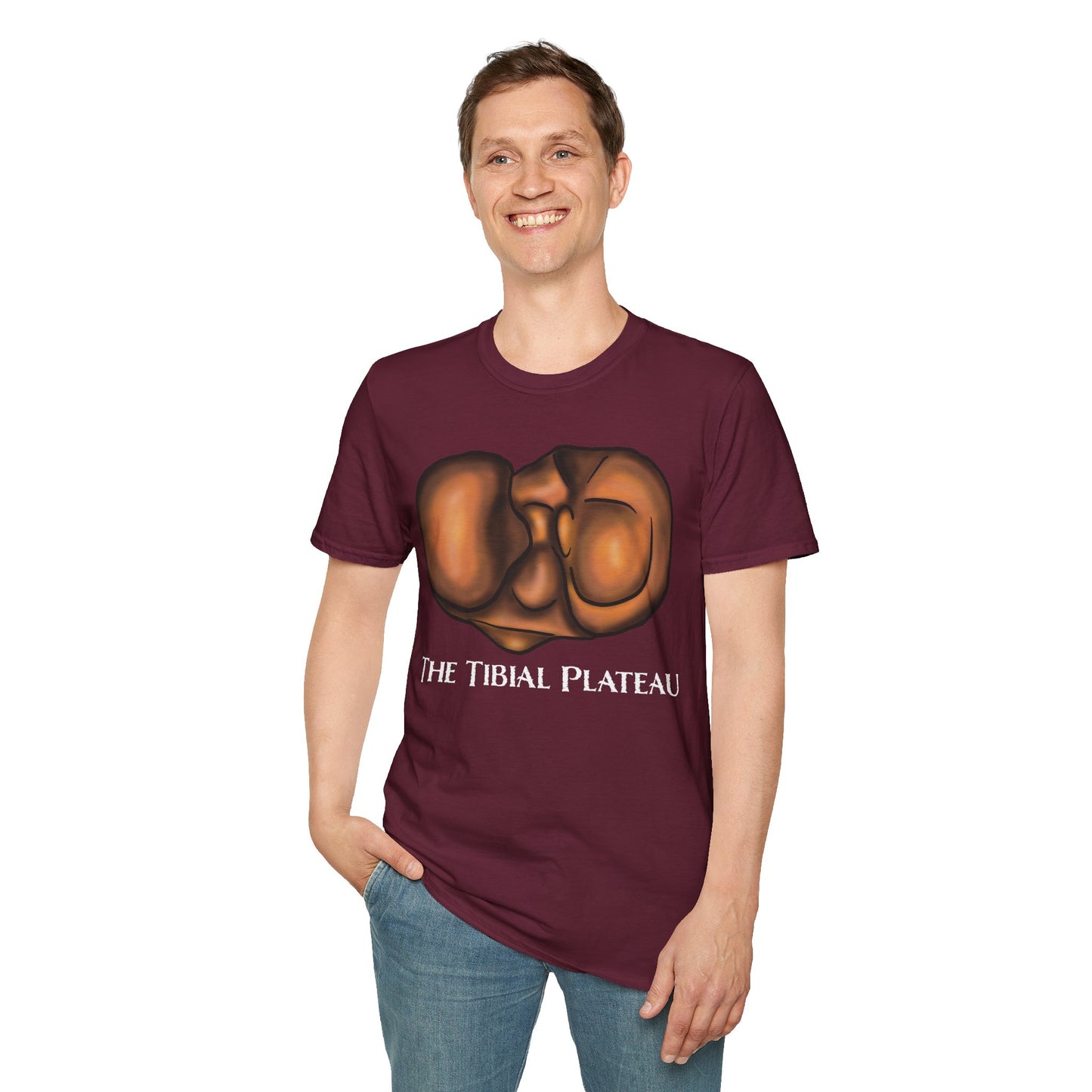 Man wearing a burgundy unisex short sleeve tee featuring a clever anatomical illustration of the tibial plateau, reimagined as a landscape with rolling hills—because who knew the tibia could be so scenic?