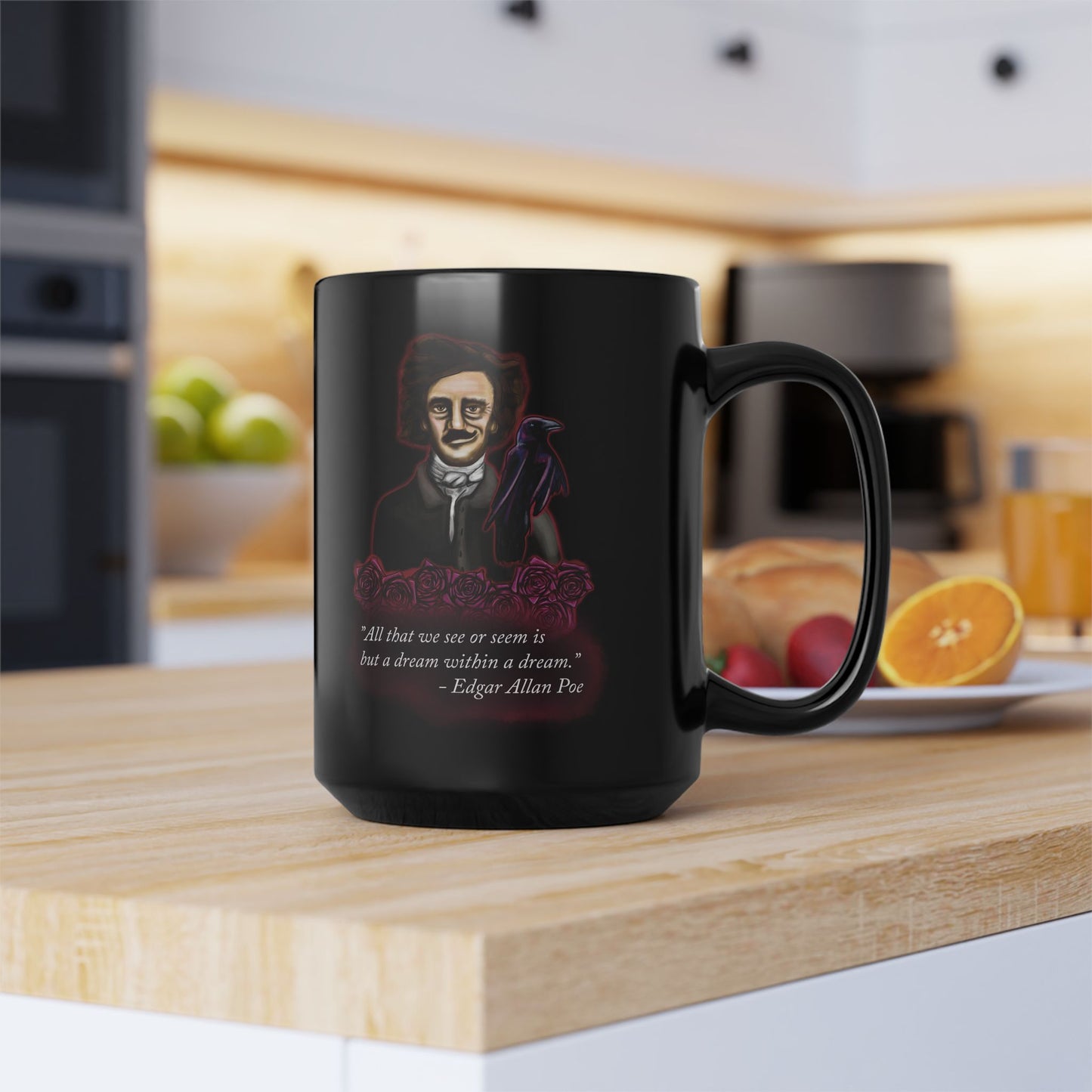 Right view of a large black coffee mug featuring a drawing of Edgar Allan Poe alongside a raven and deep red roses, with one of his famous quotes printed on the side. The mug is sitting on a kitchen counter near food.