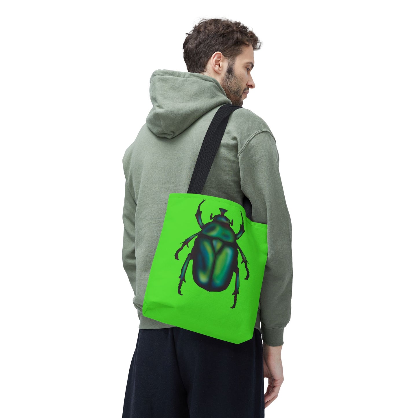 Small lime green tote bag with a black handle on a man's shoulder featuring an illustration of a June bug (green chafer beetle).