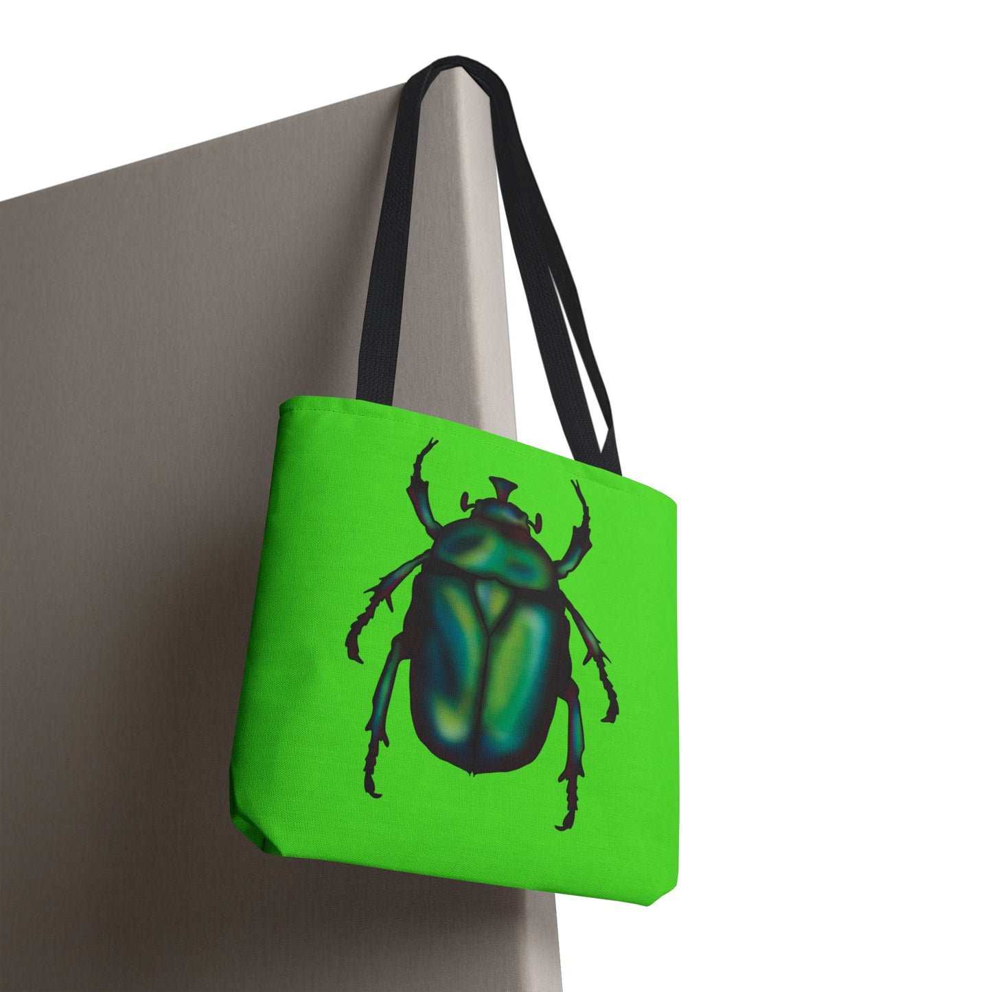 Small lime green tote bag with a black handle hanging from a chair featuring an illustration of a June bug (green chafer beetle).