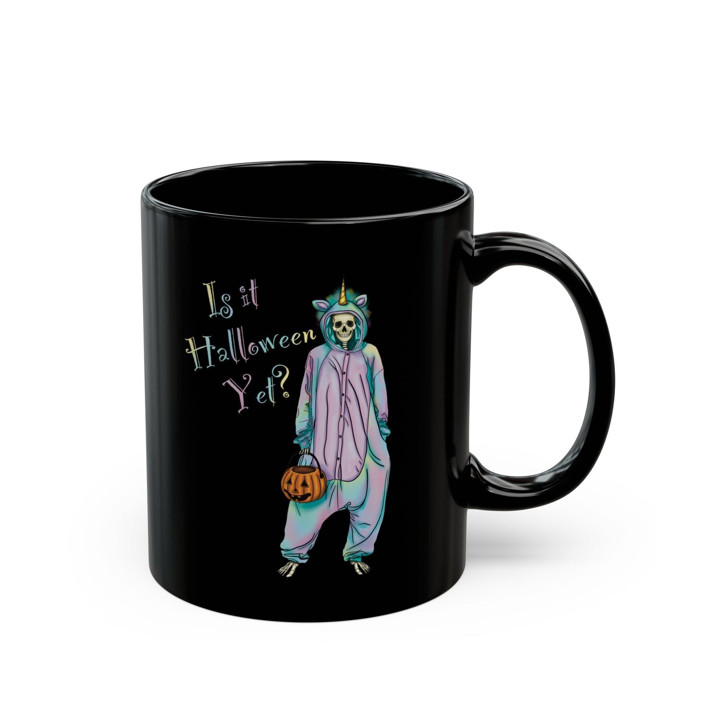 Right view of a small black coffee mug featuring a whimsical illustration of a skeleton dressed in a pastel unicorn onesie, complete with a horn and rainbow accents; the playful text reads "Is it Halloween yet?"—because spooky season should be year-round.