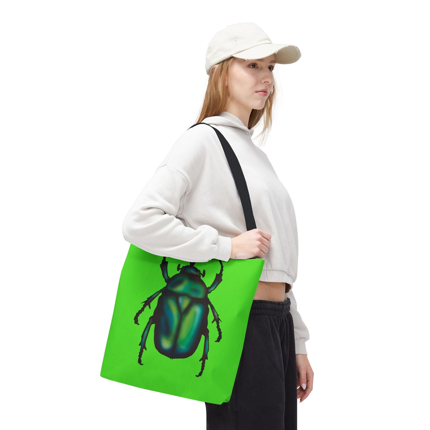 Medium lime green tote bag with a black handle on a woman’s shoulder featuring an illustration of a June bug (green chafer beetle).