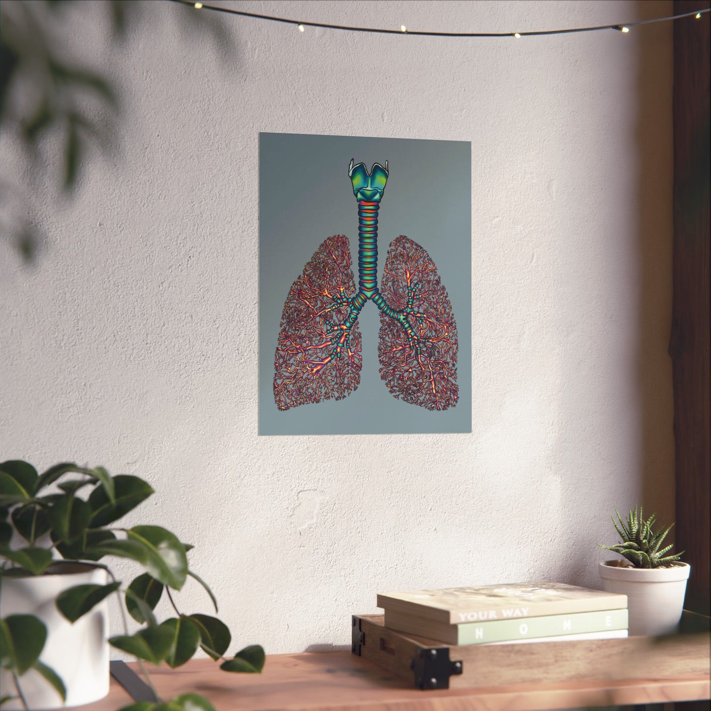 Small poster displayed on a wall in a home setting, featuring an illustration of anatomical lungs with detailed bronchial tree, trachea, and larynx, set against a blue-grey background.