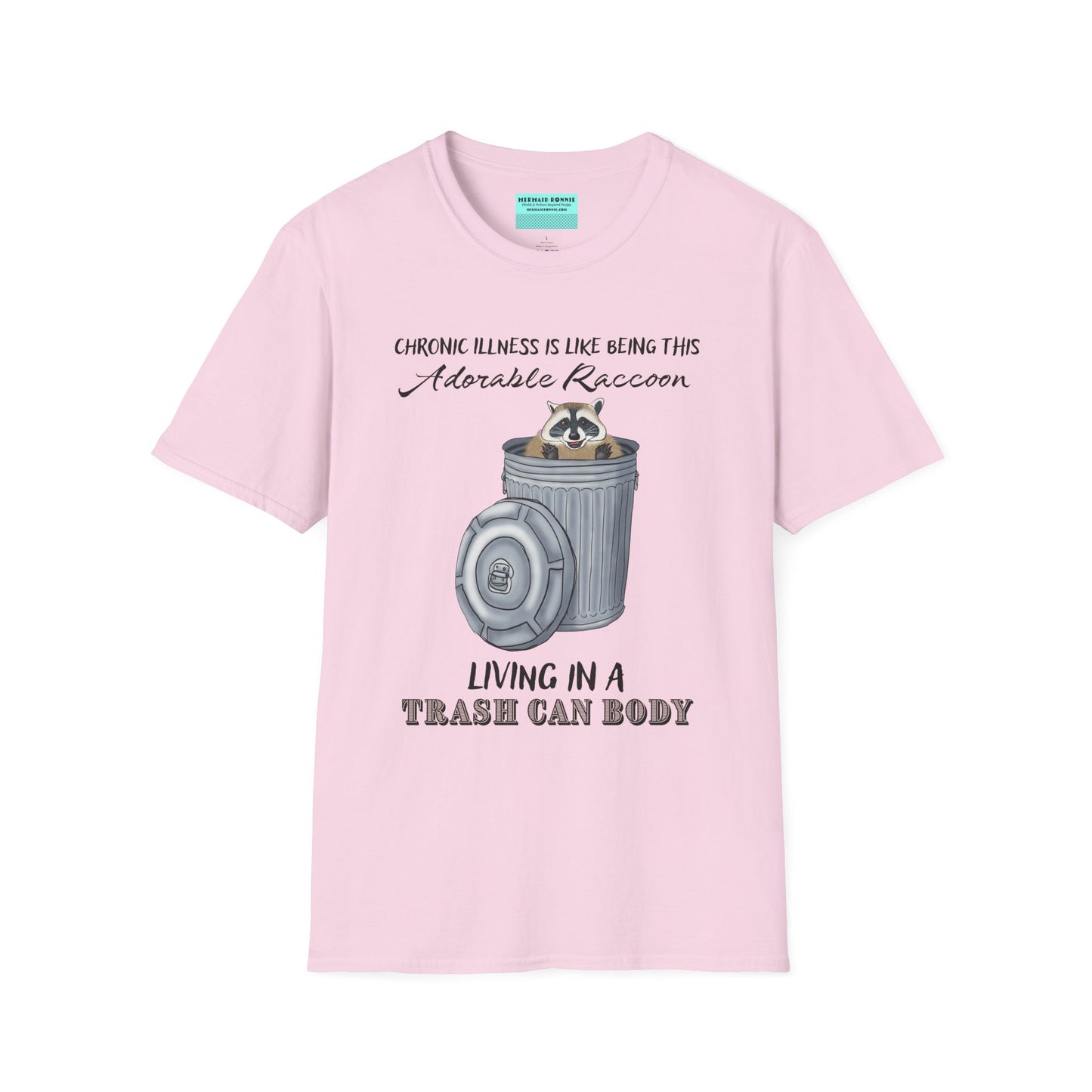 Light pink t-shirt featuring an illustration of a raccoon in a metal trash can, with the phrase 'Chronic illness is like being this adorable raccoon living in a trash can body' printed on it.