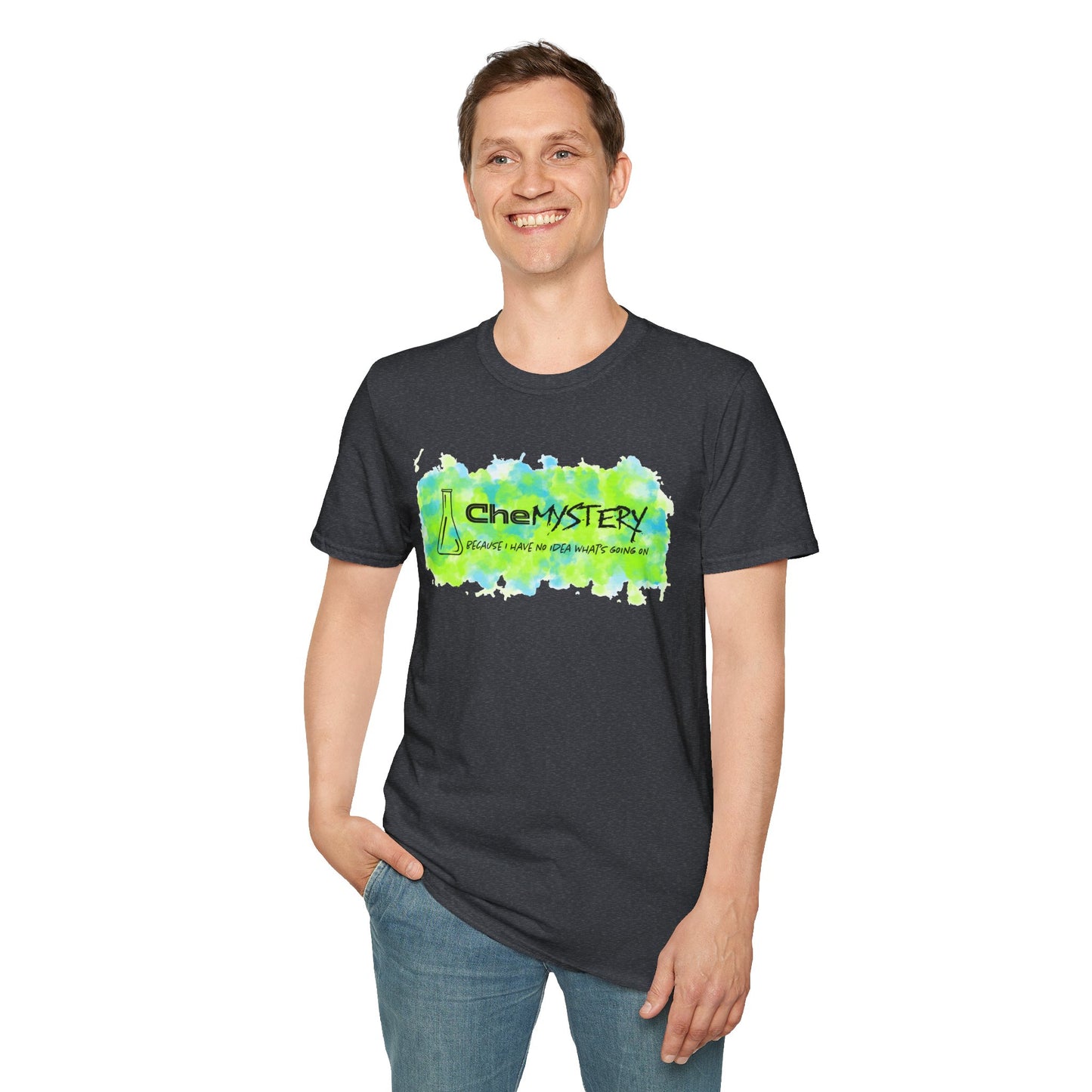 Man wearing a dark grey short-sleeve unisex t-shirt with playful watercolor-style blue and green splotches, a simple line-drawn beaker, and the witty phrase “CheMystery: because I have no idea what’s going on”—perfect for anyone who’s ever been personally victimized by the periodic table.