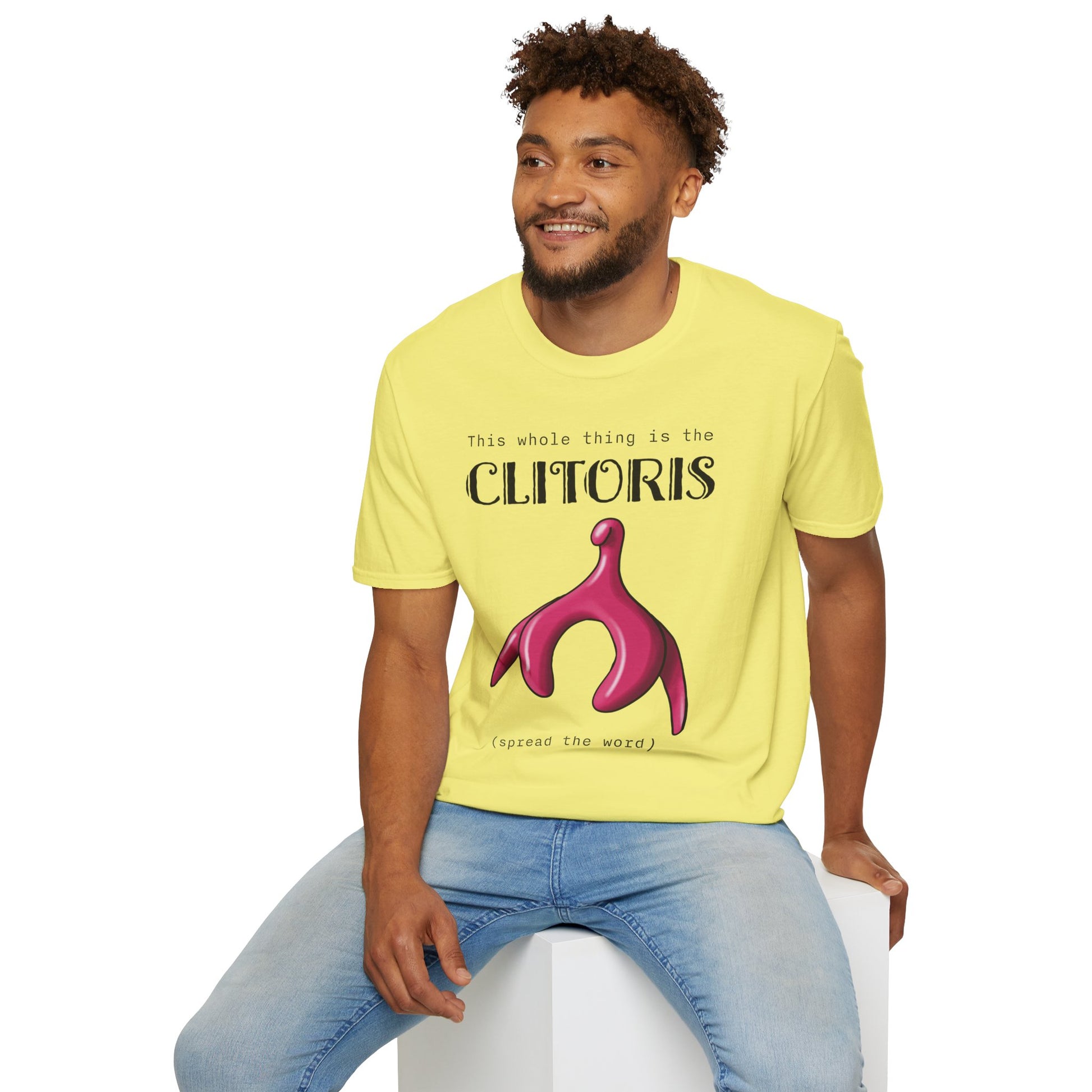 Man wearing a yellow t-shirt with an illustration of the clitoris and black text that reads 'this whole thing is the clitoris. spread the word’.
