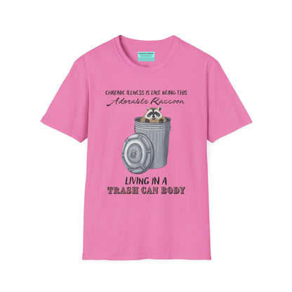 Pink t-shirt featuring an illustration of a raccoon in a metal trash can, with the phrase 'Chronic illness is like being this adorable raccoon living in a trash can body' printed on it.