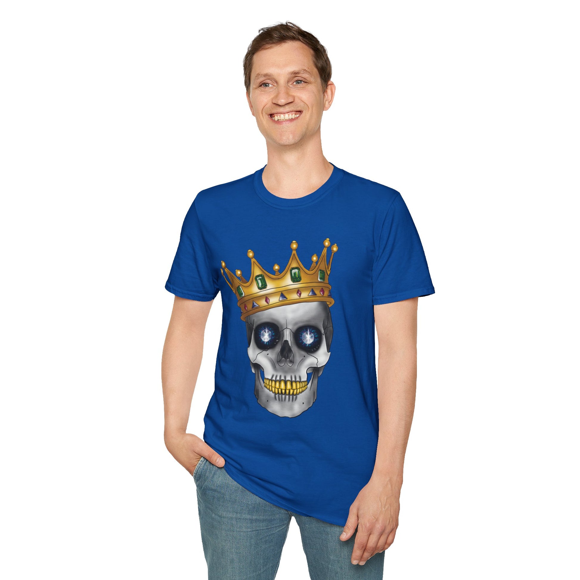 Man wearing a royal blue t-shirt featuring an anatomical skull wearing an ornate crown, with gold teeth, large sapphire gemstones in the eye sockets, and emeralds and rubies decorating the crown.