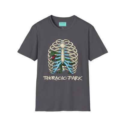 Charcoal grey unisex short sleeve tee with a clever Jurassic twist—an anatomical rib cage doubles as a prehistoric prison for a tiny T-Rex, with the punny caption "Thoracic Park" below. It's dino-mite meets anatomy class in the best way possible.