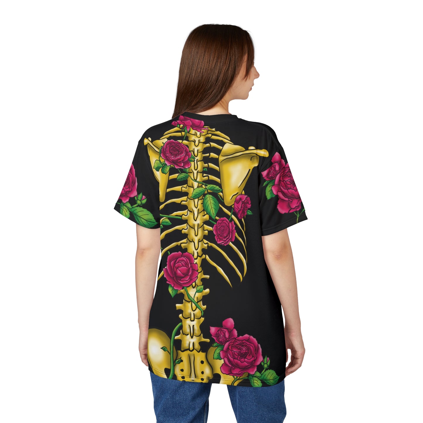Angled view of a woman wearing a unisex black athletic t-shirt featuring a gold anatomical skeleton adorned with blooming pink roses—because strength and beauty aren't mutually exclusive, and your bones deserve to blossom.