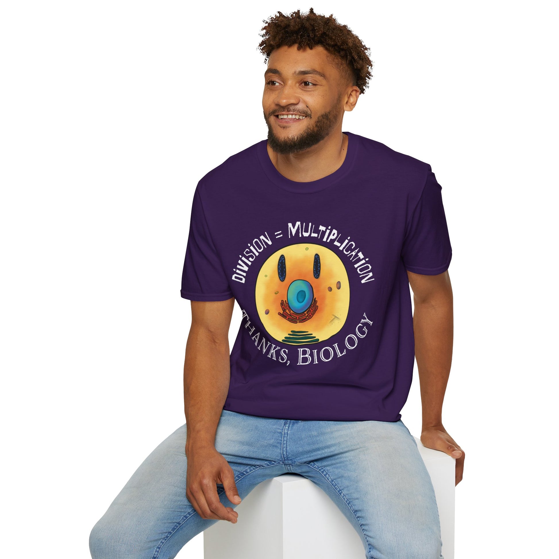 Man wearing a purple t-shirt featuring an illustration of a cell, with cellular organelles arranged to create a smiley face. The text 'Division = Multiplication. Thanks, Biology' is displayed surrounding the image.