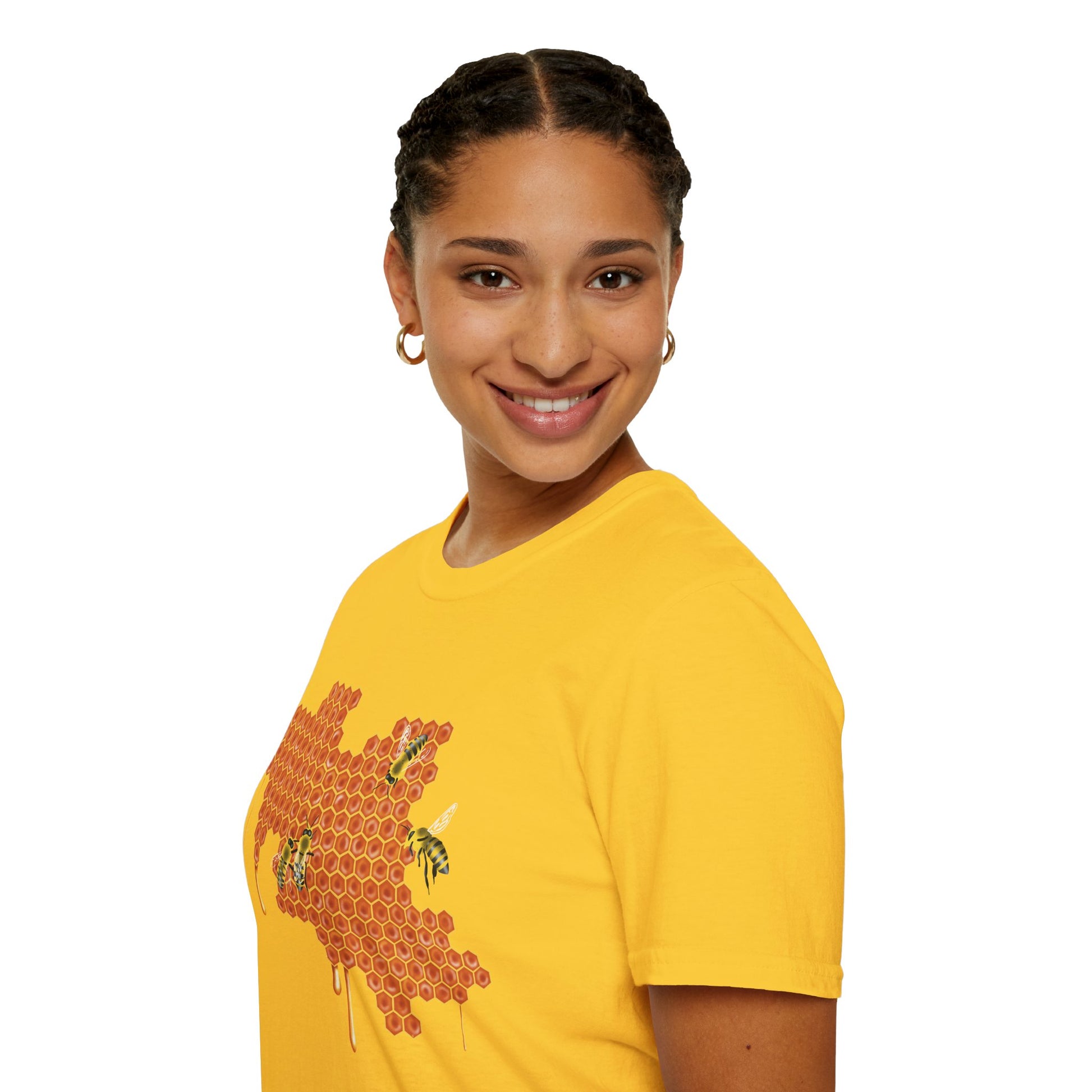 Woman wearing a yellow shirt featuring a picture of honeybees buzzing around a large piece of honeycomb with honey dripping down from it.