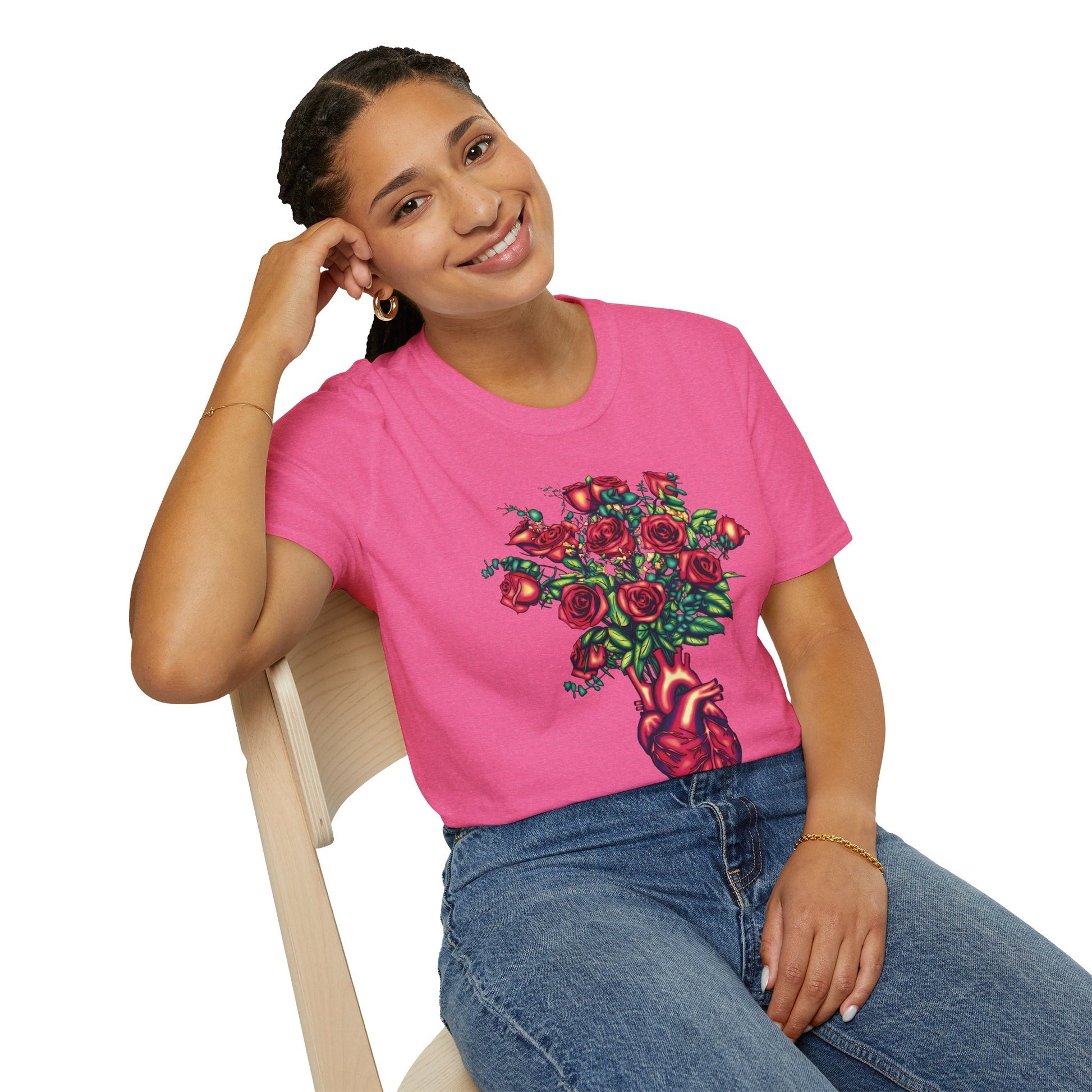 Woman wearing a pink shirt featuring an illustration of an anatomical heart used as a vase, with a bouquet of roses emerging from it.