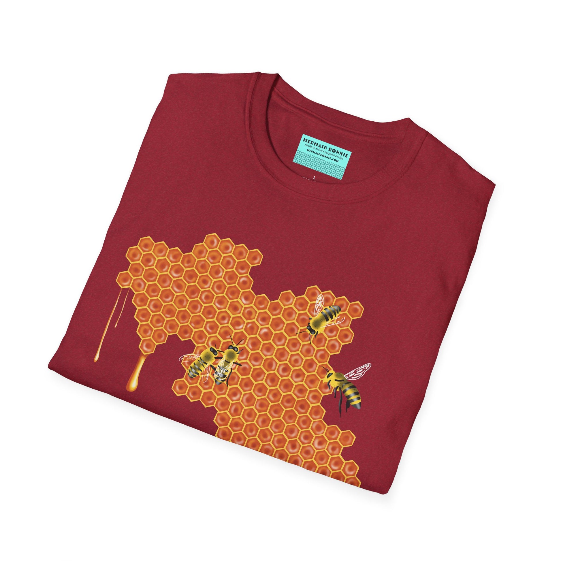 Folded red shirt featuring a picture of honeybees buzzing around a large piece of honeycomb with honey dripping down from it.