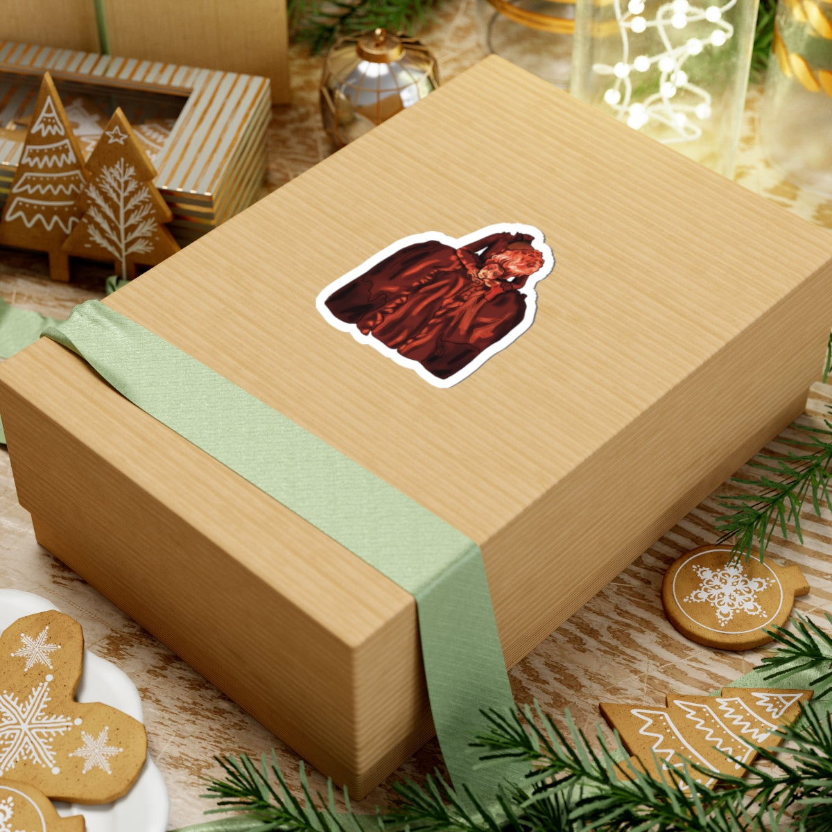 Small sticker on a package featuring a drawing of Marie Antoinette dressed in red, holding her own head after beheading.
