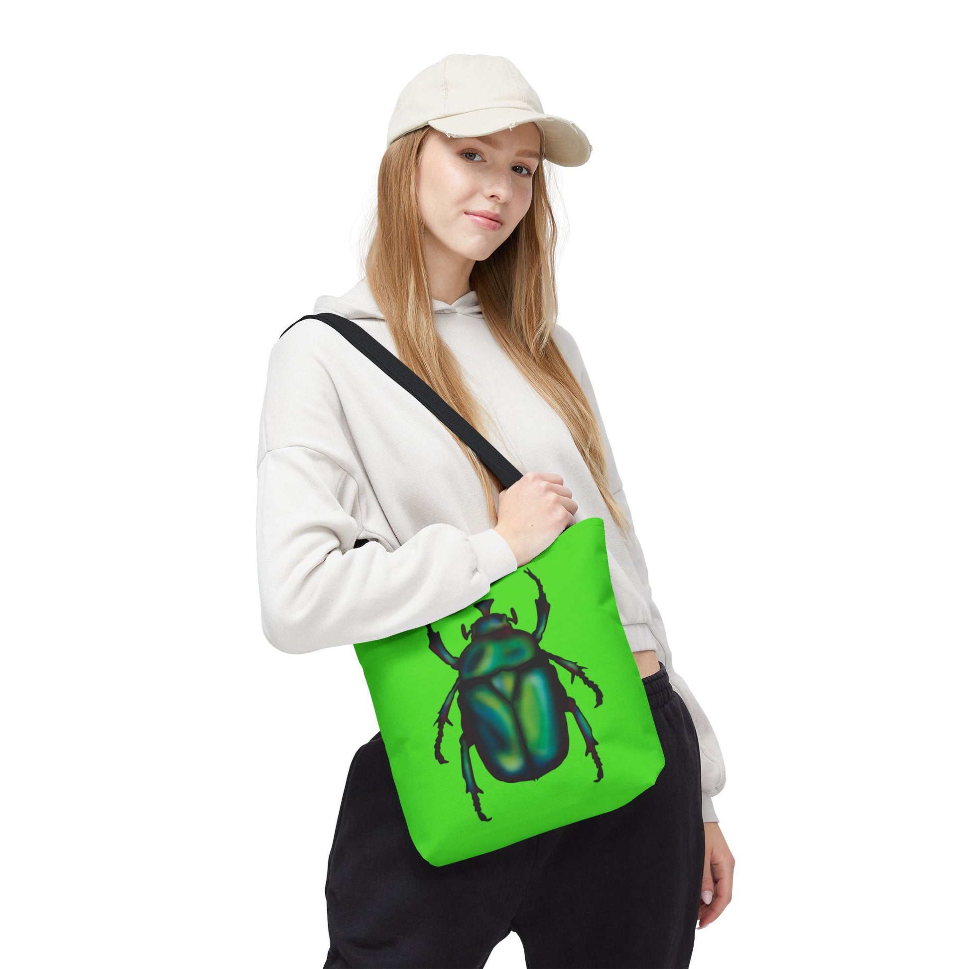 Small lime green tote bag with a black handle on a woman’s shoulder featuring an illustration of a June bug (green chafer beetle).