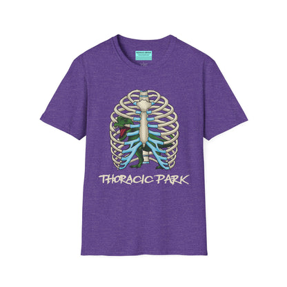 Purple unisex short sleeve tee with a clever Jurassic twist—an anatomical rib cage doubles as a prehistoric prison for a tiny T-Rex, with the punny caption "Thoracic Park" below. It's dino-mite meets anatomy class in the best way possible.