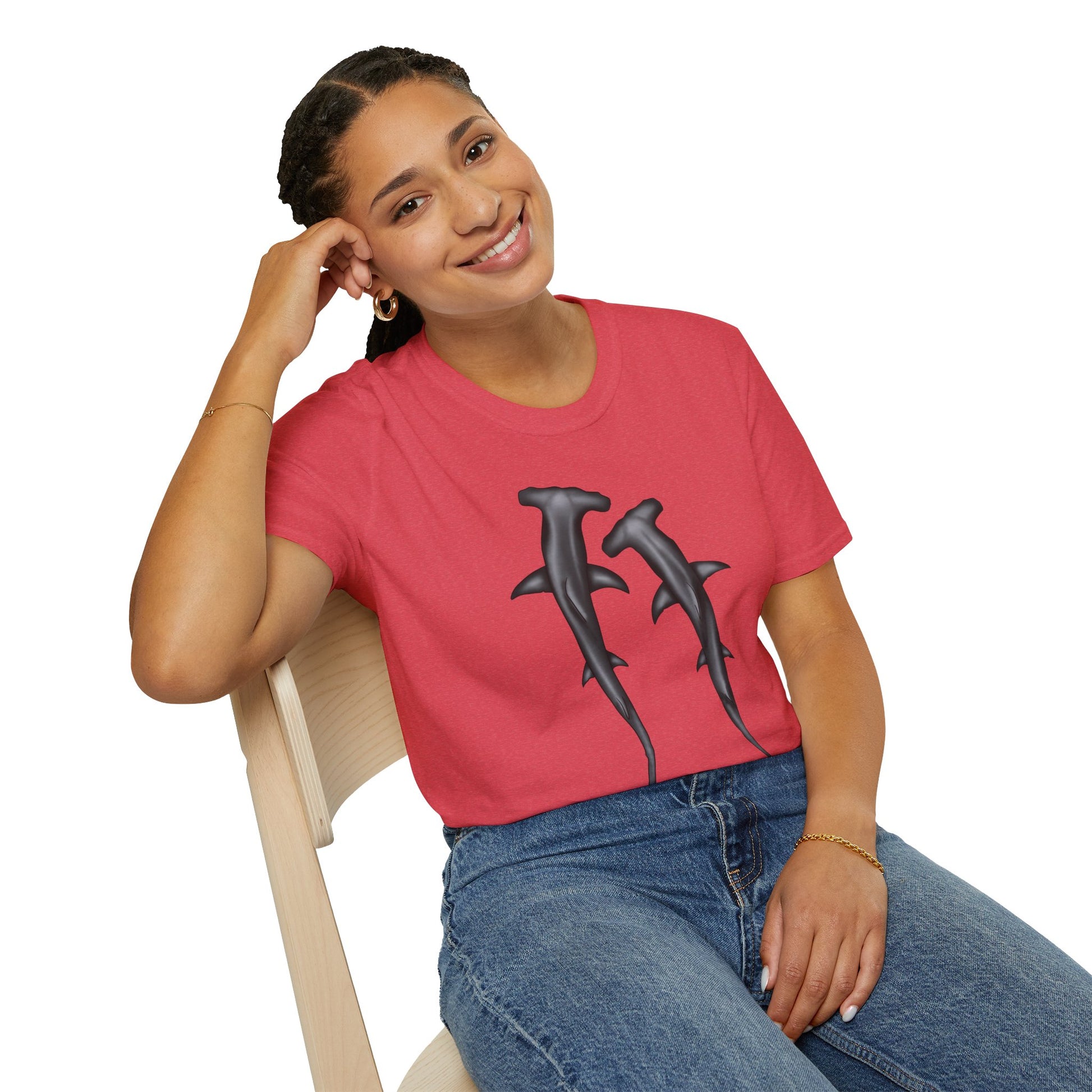 Woman wearing a coral t-shirt featuring an illustration of two hammerhead sharks.