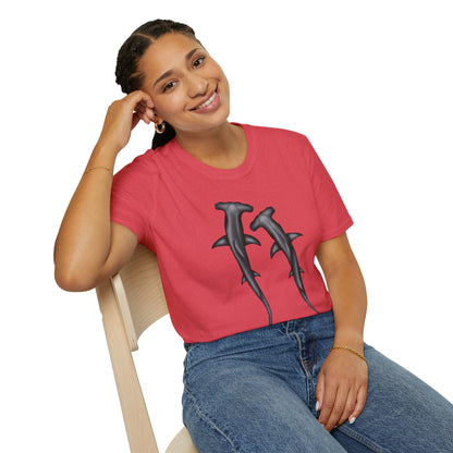 Woman wearing a coral t-shirt featuring an illustration of two hammerhead sharks.