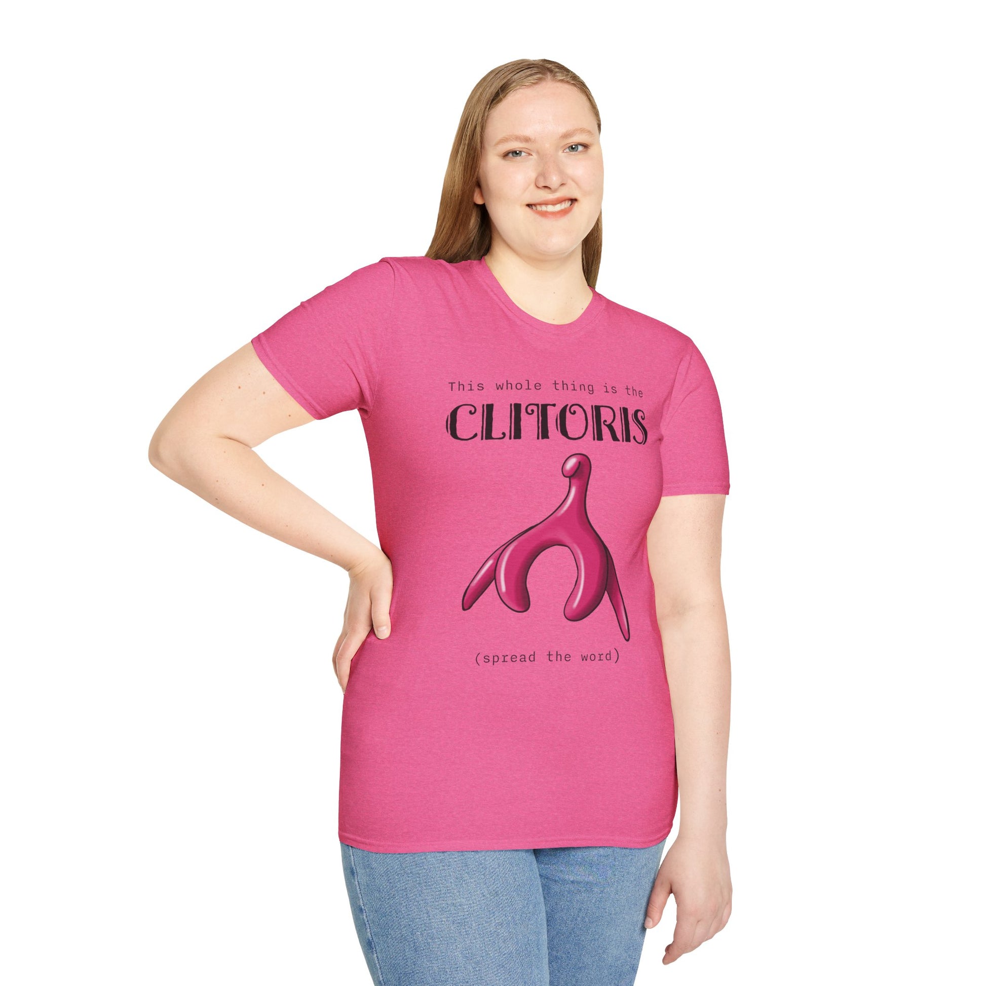 Woman wearing a pink t-shirt with an illustration of the clitoris and black text that reads 'this whole thing is the clitoris. spread the word’.