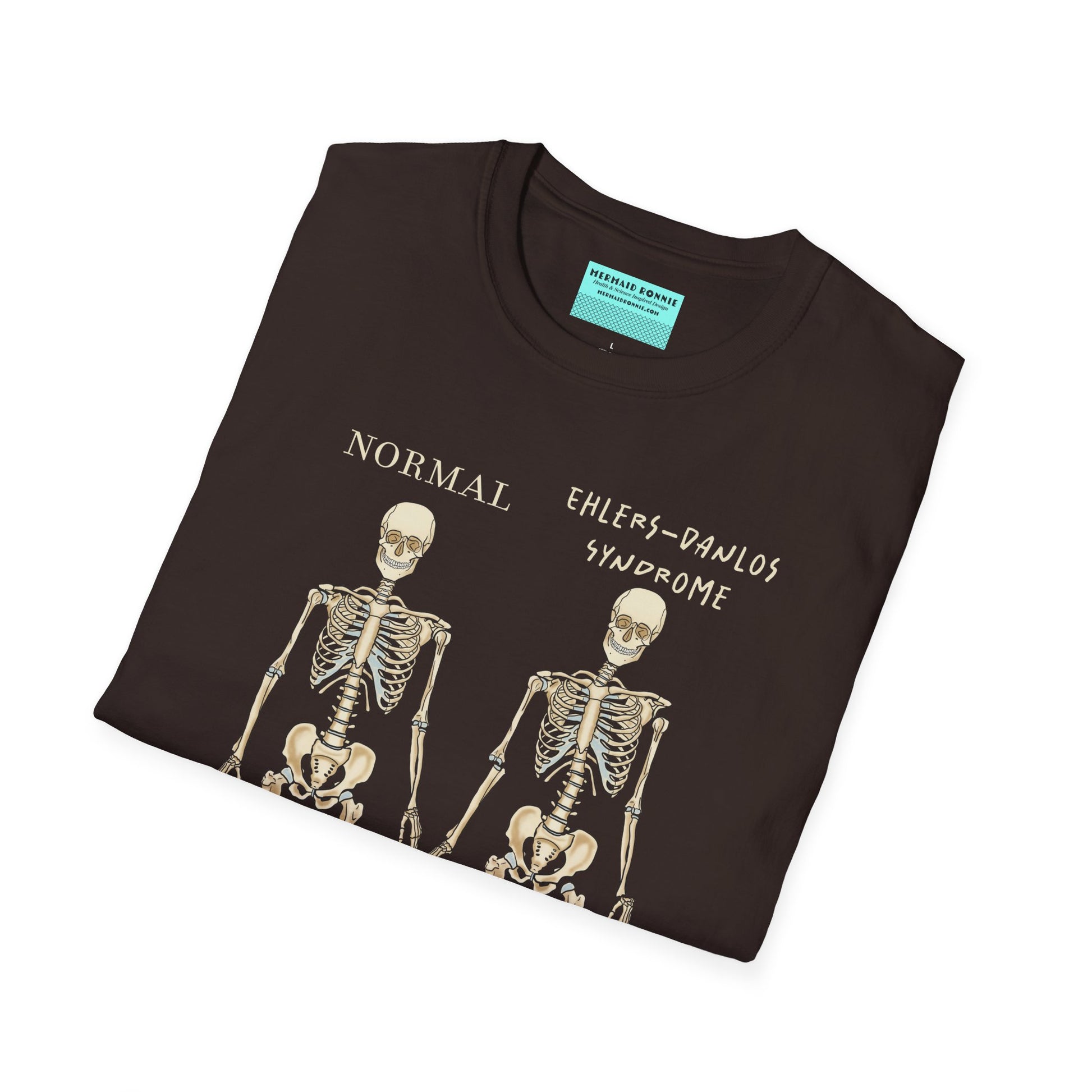 Folded brown unisex short sleeve t-shirt featuring two skeletons side by side—one labeled "normal," the other "Ehlers-Danlos Syndrome"—because connective tissue disorders deserve more visibility (and maybe a sense of humor, too).