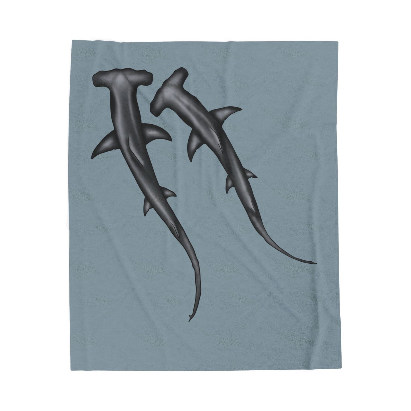 A cozy blue-grey velveteen plush blanket featuring two hammerhead sharks gliding through the fabric like it's their personal ocean—perfect for wrapping yourself in comfort with a side of bite.