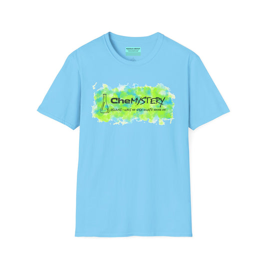 Light blue short-sleeve unisex t-shirt with playful watercolor-style blue and green splotches, a simple line-drawn beaker, and the witty phrase “CheMystery: because I have no idea what’s going on”—perfect for anyone who’s ever been personally victimized by the periodic table.
