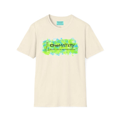 Beige short-sleeve unisex t-shirt with playful watercolor-style blue and green splotches, a simple line-drawn beaker, and the witty phrase “CheMystery: because I have no idea what’s going on”—perfect for anyone who’s ever been personally victimized by the periodic table.