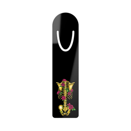 Black aluminum bookmark featuring a gold anatomical skeleton with vibrant pink roses entwined around the bones, creating a striking blend of macabre and botanical elegance.