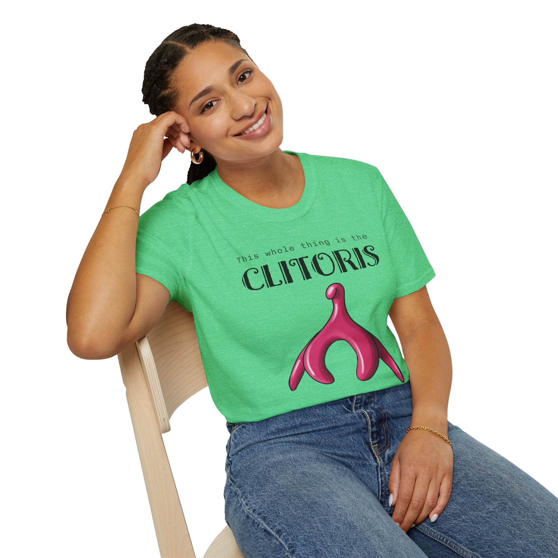 Woman wearing a green t-shirt with an illustration of the clitoris and black text that reads 'this whole thing is the clitoris. spread the word’.